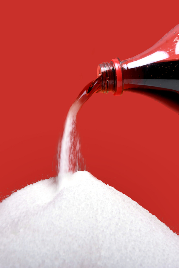 Coke pouring into sugar to show methods to cut calories 