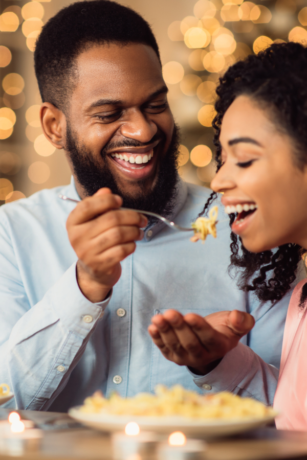 man feeding woman her favorite food to keep romance alive