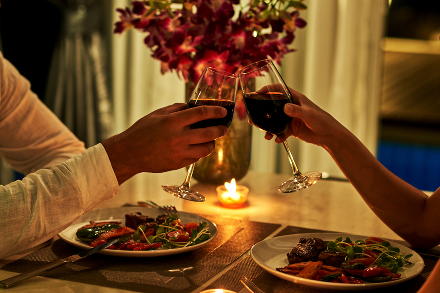 wine glasses clinking over a shared dinner to keep romance alive