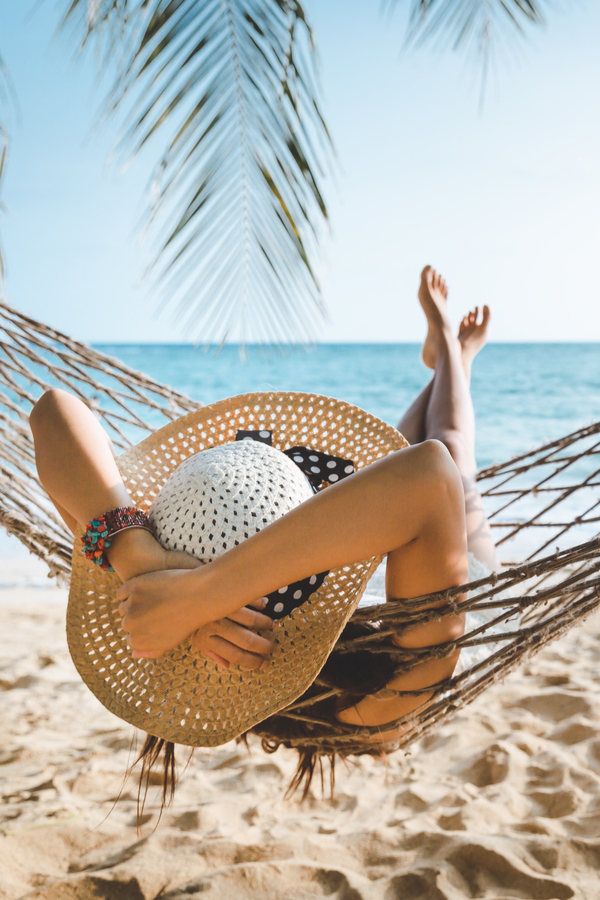 woman laying in hammock on beach