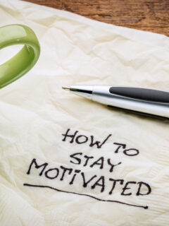 how to stay motivated note with a pen and coffee cup